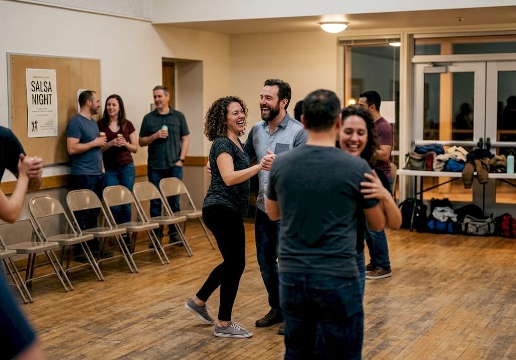Adults dancing salsa at community hall