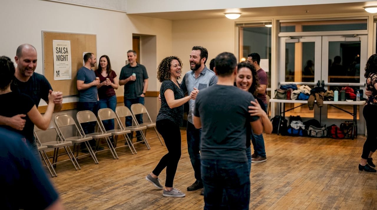 Adults dancing salsa at community hall
